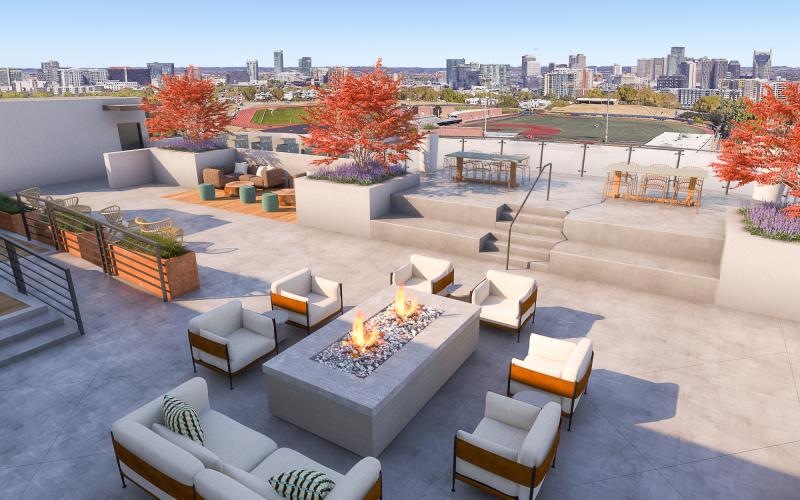a fire pit with chairs with a city in the background